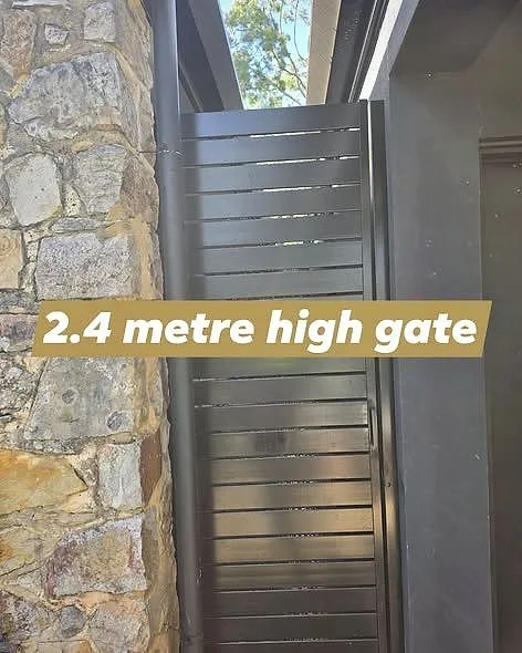 2.4 metre high slat gate beside a stone wall